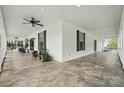 Expansive covered porch featuring seating, ceiling fans, and a concrete floor at 725 Bradshaw Rd, Mt Ulla, NC 28125