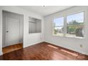 Cozy bedroom featuring hardwood floors, natural light from large window, and a closet at 7309 Pebblestone Dr # D, Charlotte, NC 28212