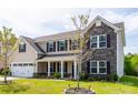 Charming two-story home with stone accents, a front porch, and attached two car garage at 7412 Greene Mill Sw Ave, Concord, NC 28025