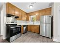 Functional kitchen with stainless steel appliances, wood cabinets, and a view of the backyard at 7905 Quail Field Dr, Charlotte, NC 28227