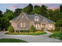 Beautiful exterior of the home with stone and brick accents and manicured landscaping at 8670 Arbor Oaks Cir, Concord, NC 28027