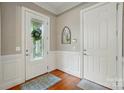 Inviting foyer featuring hardwood floors, paneled walls, and a decorative front door with leaded glass at 9652 Wheatfield Rd, Charlotte, NC 28277