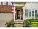 Charming front porch featuring flowers, stylish lighting, and a classic black door with glass details at 9652 Wheatfield Rd, Charlotte, NC 28277