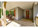 Inviting front porch with wooden rocking chairs and table next to stained wood front door at 1006 Chambers Rd, York, SC 29745