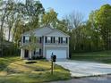 Beautiful view of this two-story home, showing lush trees, a driveway, and landscaped yard at 1070 Glenbriar Ct, Woodleaf, NC 27054