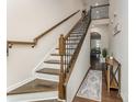 Welcoming foyer featuring hardwood floors, decorative staircase with a long runner, and a console table at 11062 Discovery Nw Dr, Concord, NC 28027