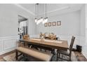 Bright dining room featuring a wooden table, pendant lighting and decorative wall paneling at 12604 Congregation Dr, Charlotte, NC 28278