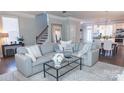 Bright living room with neutral tones, a comfortable gray sofa, and a glass coffee table at 1424 South St, Cornelius, NC 28031