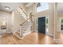 Bright foyer featuring hardwood floors, a staircase, and a large window above the front door at 15535 Eagleview Dr, Charlotte, NC 28278
