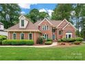 Well maintained brick two-story home featuring manicured lawn and mature trees under a cloudy sky at 15535 Eagleview Dr, Charlotte, NC 28278