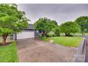Spacious driveway leading to a two-car garage, surrounded by mature trees and lush landscaping at 2150 Quiet Creek Pl, Rock Hill, SC 29732