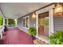 Charming front porch with a welcome mat, featuring a beautifully stained wood floor and exterior lighting at 2150 Quiet Creek Pl, Rock Hill, SC 29732
