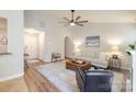 Open-concept living room with wood floors, neutral paint and a comfortable seating arrangement around a central ottoman at 2416 Hart Rd, Charlotte, NC 28214