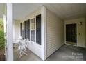 Inviting front porch featuring a cozy seating area, perfect for enjoying the outdoors with classic black shutter accents at 2416 Hart Rd, Charlotte, NC 28214