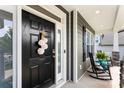 Inviting front door with elegant black finish, decorative wreath, and charming porch with rocking chairs at 2936 Shumard Dr, Gastonia, NC 28054