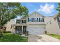 Two-story home with a front porch, two-car garage and a mix of brick, siding, and stone exterior finishes at 314 Pulaski Sw Dr, Concord, NC 28027