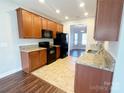 Well-lit kitchen with granite countertops and black appliances, seamlessly connects to the dining area at 4143 Kenton Glenn Nw Ct, Concord, NC 28027