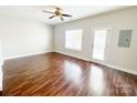Spacious living room boasts a ceiling fan, wood floors, and a glass door leading outside at 4143 Kenton Glenn Nw Ct, Concord, NC 28027