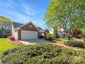 Well-maintained home with a two-car garage, lush lawn, and manicured shrubbery create inviting curb appeal at 4656 Chaucer Nw Pl, Concord, NC 28027