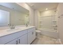 Bright bathroom featuring a double sink vanity with modern fixtures, a large mirror, and a shower-tub combo at 5025 Poplin Vly, Cherryville, NC 28021