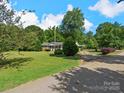 A single-story home features a long driveway and beautiful, mature trees at 5159 Taxahaw Rd, Lancaster, SC 29720