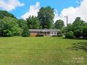 A cozy, single-story home boasts a well-kept lawn with mature trees at 5159 Taxahaw Rd, Lancaster, SC 29720