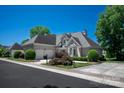 Stately home showcasing professional landscaping, a three-car garage, and a well-maintained lawn at 5335 Lower Shoal Creek Ct, Charlotte, NC 28277