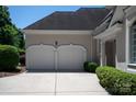 Spacious two-car garage with decorative doors and a wide driveway surrounded by green landscaping at 5335 Lower Shoal Creek Ct, Charlotte, NC 28277
