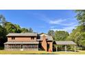 Rear exterior of brick home with screened-in porch, chimney, and carport under a bright blue sky at 611 Stowe Rd, Clover, SC 29710