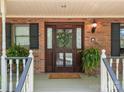 Inviting front entrance with a beautifully crafted wood door and manicured potted plants at 627 S Chapel St, Landis, NC 28088