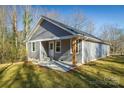 Rear exterior featuring siding, windows, and a concrete patio space surrounded by a well maintained lawn at 721 32Nd Ne St, Conover, NC 28613