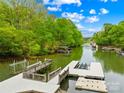 Picturesque lake view featuring multiple docks, lush trees, and calm waters on a sunny day at 8451 Ridgewood Rd, Sherrills Ford, NC 28673