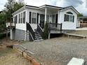 Attractive home with white siding, black shutters, and well-maintained gravel driveway at 102 Eagle Ln, New London, NC 28127