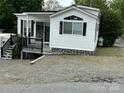 Inviting single-story home with white siding, black shutters, and a covered porch area at 102 Eagle Ln, New London, NC 28127