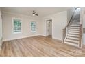 Bright living room with natural light, hardwood floors, and a staircase, creating an open and inviting atmosphere at 106 Walters St, Huntersville, NC 28078