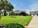 A spacious lawn surrounds a brick home with a detached garage and well-maintained landscaping at 107 Cedar Lake Dr, Statesville, NC 28625