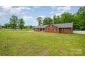 Beautiful red brick home with a well-manicured lawn and a lovely countryside backdrop in a peaceful neighborhood at 1376 Garland Ln, Lincolnton, NC 28092