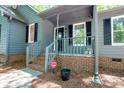 Inviting front porch with brick accents, black shutters and well manicured front yard at 1522 Stafford Ext, Monroe, NC 28110