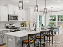 Bright kitchen with white cabinets, a large kitchen island, modern stainless-steel appliances, and contemporary pendant lighting at 181 Montgomery Pl # 726, Mount Gilead, NC 27306