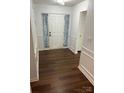Inviting entryway with hardwood floors, elegant wainscoting, and a classic white front door at 1863 New Castle Dr, Fort Mill, SC 29707