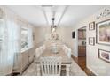 Bright dining room with a rustic wood table, stylish chandelier, and large windows at 1988 Clear Brooke Dr, Kannapolis, NC 28083