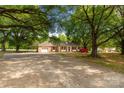 Well-kept single-story home with attached garage, large driveway, manicured lawn, and mature trees offering ample shade at 2007 Green Peach Rd, Lancaster, SC 29720