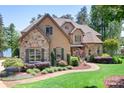 Beautiful home with stone accents, manicured landscaping, and a winding walkway leading to the entrance at 202 Timber Lake Dr, Troutman, NC 28166
