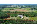 Expansive property showcasing the home's location surrounded by lush greenery and open fields at 25674 Old School Rd, Oakboro, NC 28129