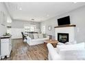 Bright living room with a cozy fireplace, comfortable seating, and hardwood floors at 25674 Old School Rd, Oakboro, NC 28129