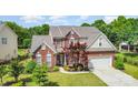 Aerial view of brick home with a manicured front lawn and a large two-car garage at 3007 Sandbox Cir, Indian Trail, NC 28079