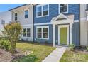 Close up of a lovely townhome with a green door and beautiful landscaping at 3015 Howell Mill Rd, Charlotte, NC 28208