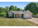Charming single story home boasts a lovely landscaped yard, inviting front porch, and attached garage at 308 Southland Rd, Huntersville, NC 28078