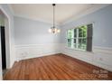 Traditional dining room showcasing hardwood floors, chair rail molding, and a stylish chandelier at 461 Pier Point Nw Ct, Concord, NC 28027