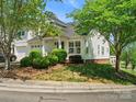 Well-maintained home with green lawn, mature trees, and tidy landscaping around the foundation at 6647 Vlosi Dr, Charlotte, NC 28226